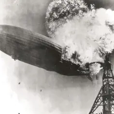 Płonący sterowiec Hindenburg eksploduje nad wieżą podczas lądowania.