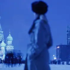 Nocny plac Czerwony, zamazane postacie ludzi, świątynia Wasyla Błogosławionego i Kreml. Rosja liczba ludności w zimowej scenerii.