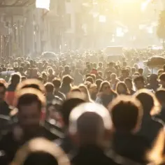 Tłum ludzi na ulicy, przypominający gęstą populację USA. Słońce przebija się przez tłum, tworząc jasną poświatę.