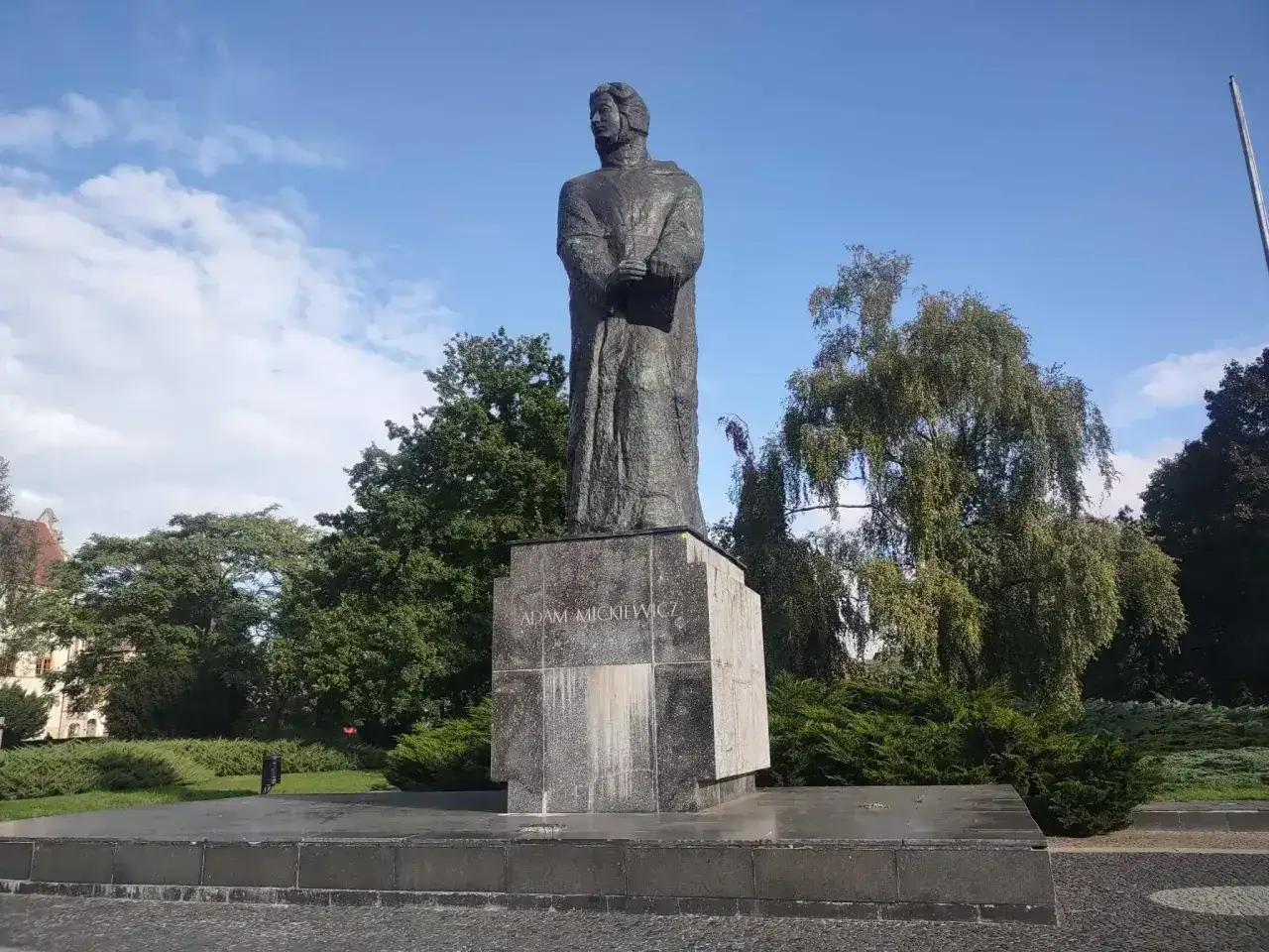 Pomnik Adama Mickiewicza, symbol polskiego romantyzmu, stoi dumnie wśród zieleni.