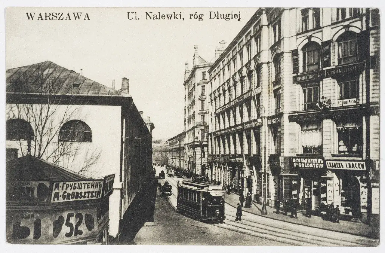 Ulica Nalewki w Warszawie, widok na kamienice i tramwaj. Nazwy sklepów jak 